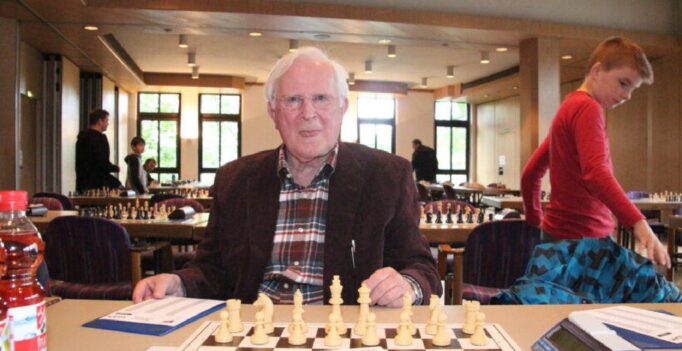 Klaus Ponnath sitzt vor einem Schachbrett.
