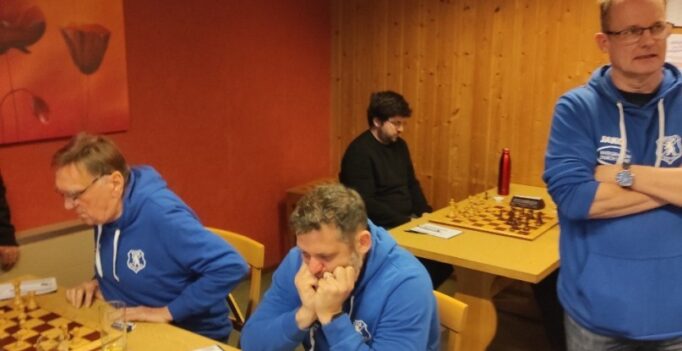 Indoor chess club scene: players in blue hoodies at wooden tables, chessboards and clocks in play.